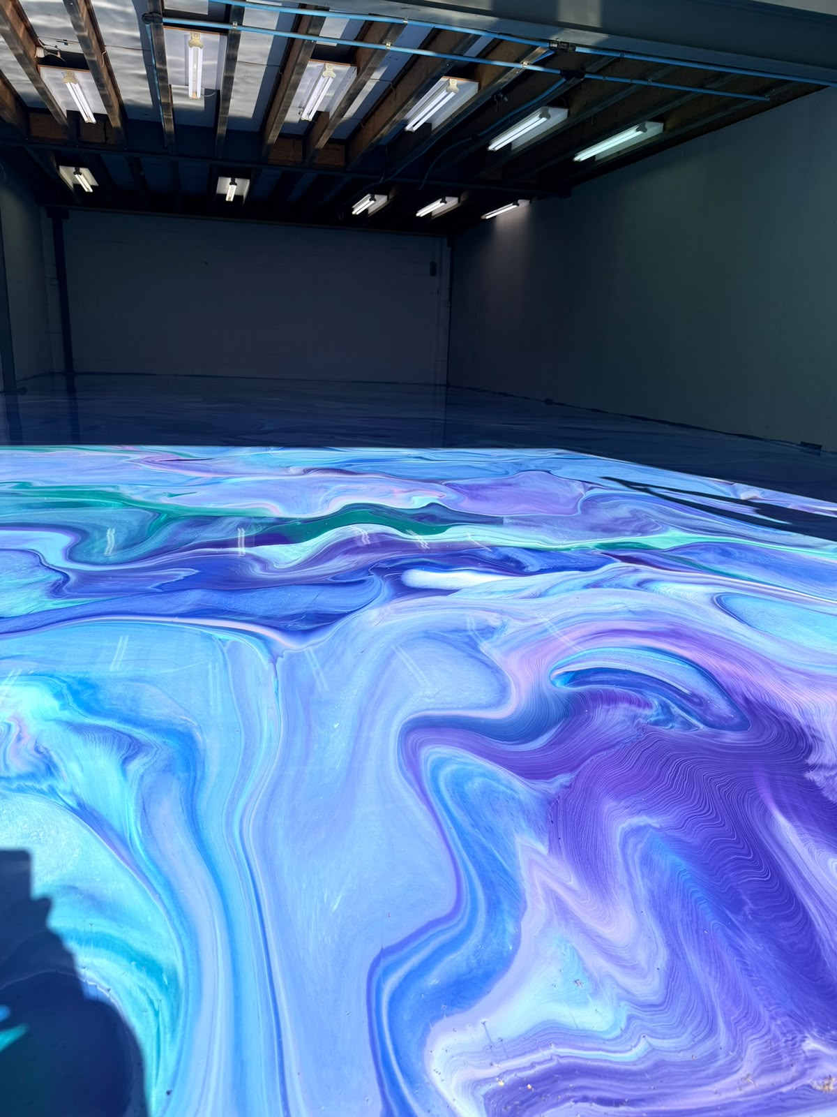 Glossy blue metallic epoxy floor in a studio